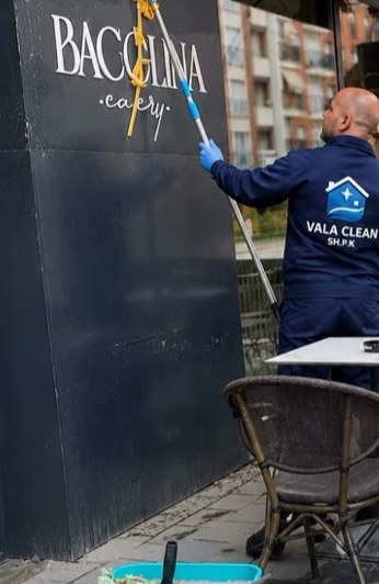 Punëtor i Vala Clean duke pastruar xhamat e një lokali