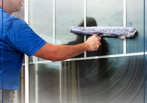 Punëtor i Vala Clean duke pastruar xhamat e mëdha